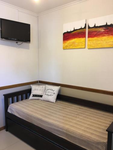 a bedroom with a bed and a flat screen tv at Aires de la Villa in Villa Carlos Paz