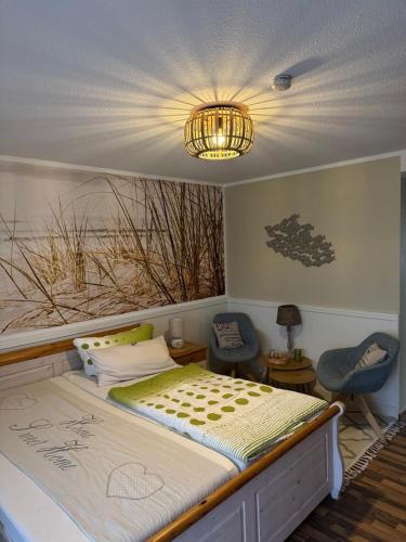 a bedroom with a bed and a chandelier at Pension Mien Fründt in Baabe