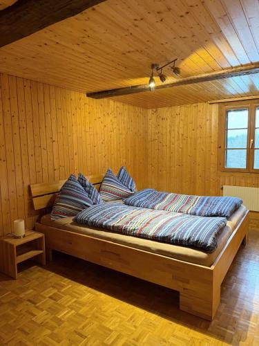 a bedroom with a bed in a wooden room at Rustikale Wohnung auf dem Bauernhof in Malters