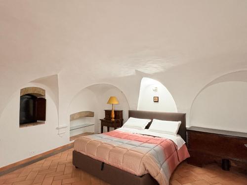 a bedroom with a bed in a white room at DIMORA MedioEvo in Orvieto