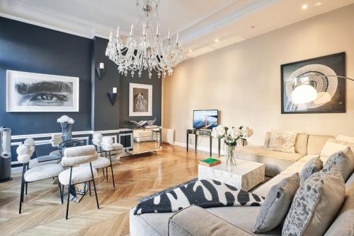 un salon avec un canapé et un lustre dans l'établissement Spacious flat - Champs Elysées, à Paris