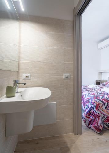 a bathroom with a sink and a bed at Pantaleo Rooms in Santadi