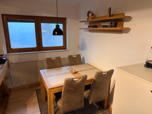 a kitchen with a wooden table and chairs in a room at Kuckucksnest in Ühlingen-Birkendorf