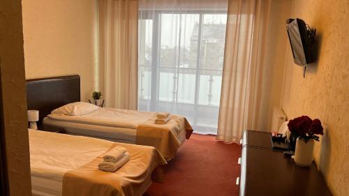 a hotel room with two beds and a window at Neptun in Legnica