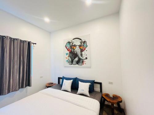 a bedroom with a bed with a picture of an elephant at Modern Elephant Lagoon Villa in Ko Chang