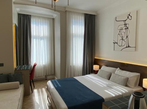 a hotel room with a large bed and a chair at Pera Standard Rooms in Istanbul