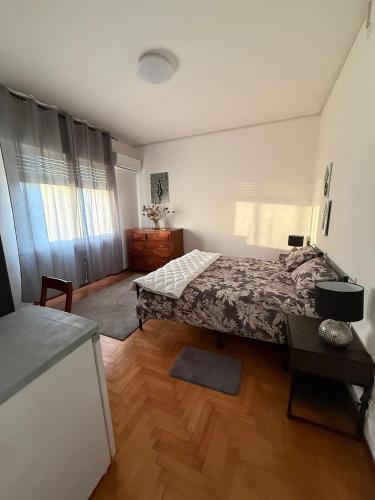 a bedroom with a bed and a wooden floor at Tamika's House in Udine