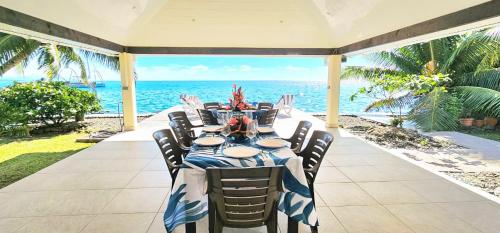 a table on a patio with the ocean in the background at Raiatea Sunrise villa in Taputapuapea