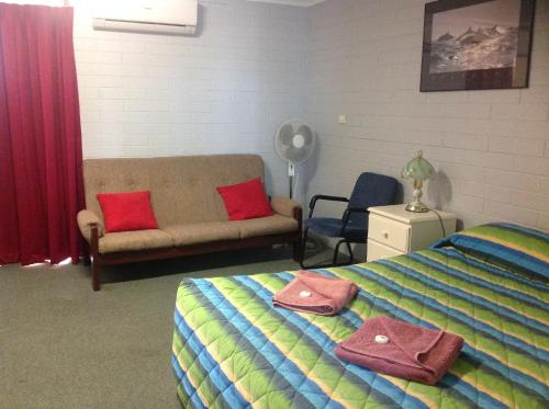 a bedroom with a bed and a couch at Murray Bridge Motor Inn in Murray Bridge