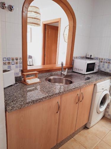 a kitchen counter with a sink and a microwave at Altos del Mar in Santa Pola