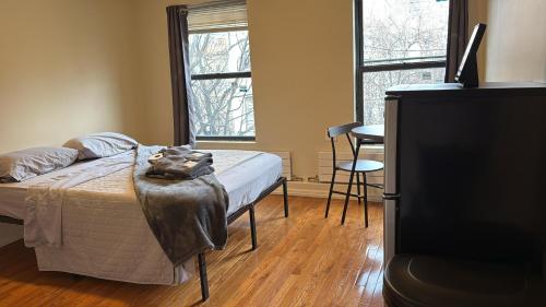 a bedroom with a bed and a tv and two windows at New York City Guesthouse 3 in New York