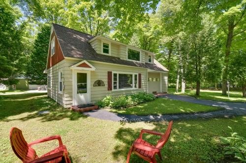 a house with two red chairs in the yard at The Carriage House Walk to Peninsula State Park in Ephraim