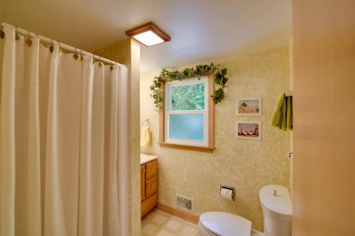 a bathroom with a shower curtain and a toilet at The Carriage House Walk to Peninsula State Park in Ephraim