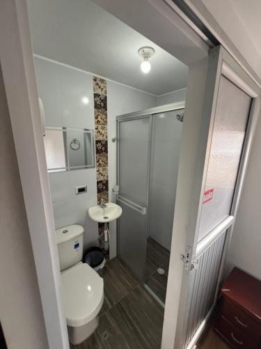 a bathroom with a shower and a toilet and a sink at Hotel El paraiso Funza in Funza