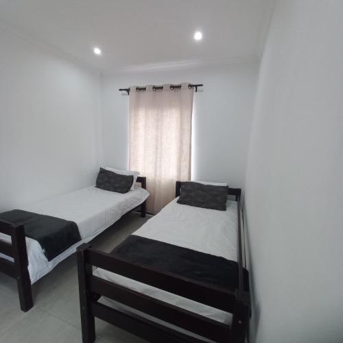 a bedroom with two beds and a window at 200 on Genazzano in Densainagar