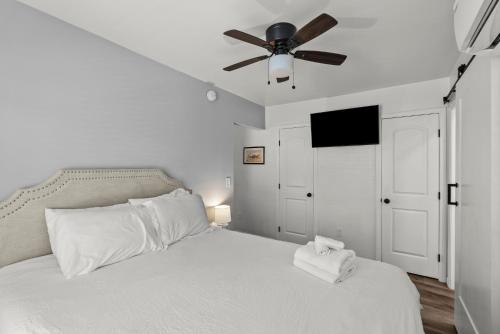 a bedroom with a white bed with a ceiling fan at Mint Julep - Studio in Downtown Lexington in Lexington