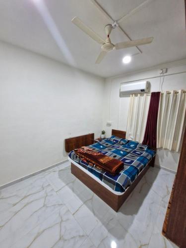 a bedroom with a bed and a ceiling fan at Laximi Niwas in Nashik