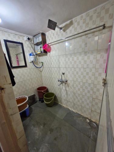 a bathroom with a shower with buckets in it at Laximi Niwas in Nashik
