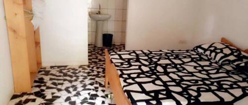 a bedroom with a black and white comforter on a bed at Contany Counda in Abémé