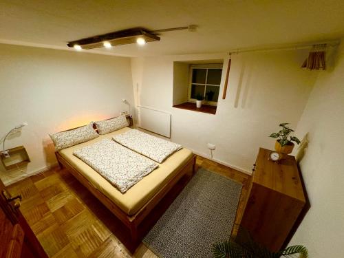 a small bedroom with a bed and a window at Genau so - Allgäu! Sau Gemütlich in Maierhöfen