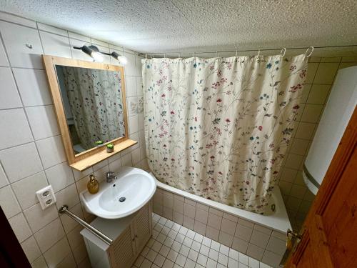 a bathroom with a sink and a shower curtain at Genau so - Allgäu! Sau Gemütlich in Maierhöfen