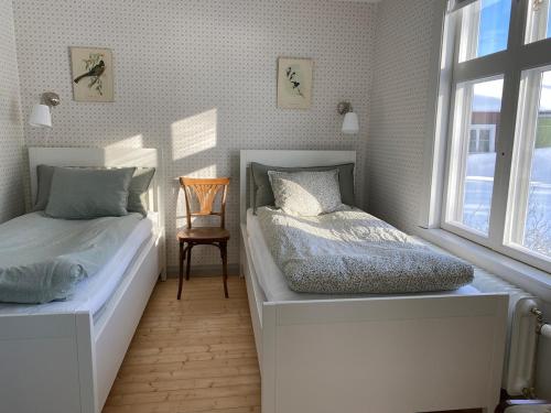 a bedroom with two beds and a window at Charmig stuga på bondgård in Norrfjärden