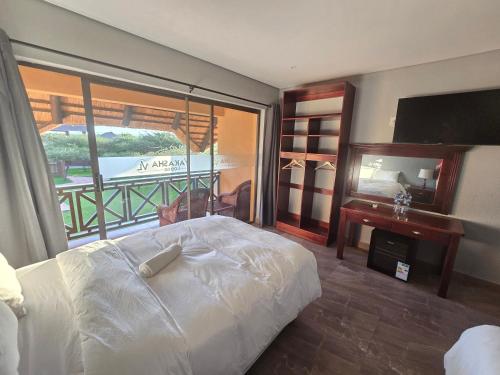 a bedroom with a bed and a large window at Vakasha Lodge in Siphofaneni