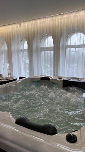 a bath tub filled with water with windows at APETIKO APARTMENTs in Kyiv