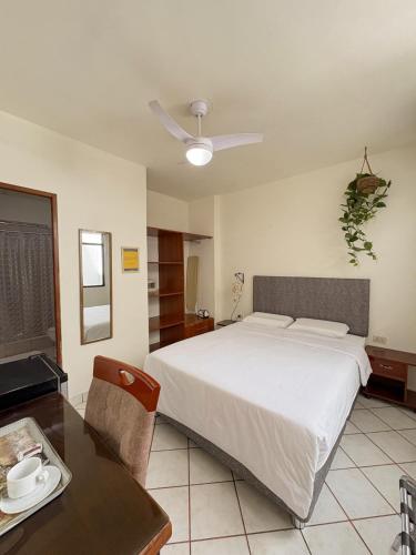 a bedroom with a large bed and a table at Hospedaje Gran Imperial in Tumbes