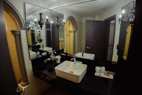 a bathroom with a sink and two mirrors at Hotel & Spa Hacienda Baruk in Zacatecas