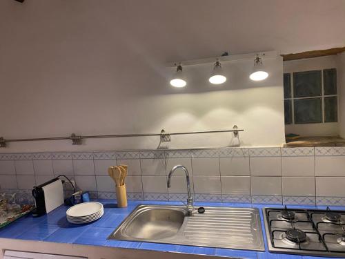 a kitchen with a sink and a stove and lights at Luce su Civita in Lubriano