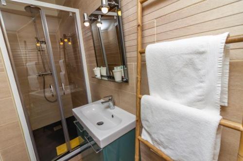 a bathroom with a sink and a white towel at Camping Hôtel Maui in Tournon-sur-Rhône