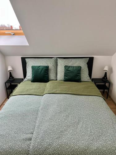 a bedroom with a large bed with green pillows at Jolcsi Apartman in Balatonfüred