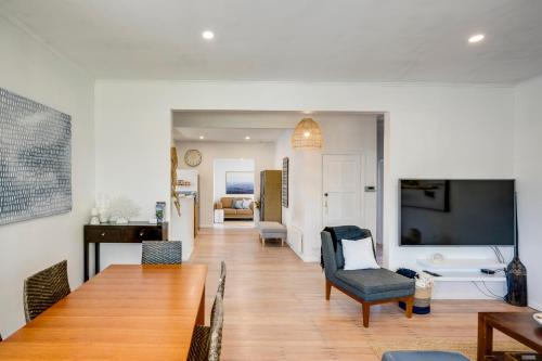 a living room with a dining table and a television at Bird and Fish - Napier Holiday Home in Napier