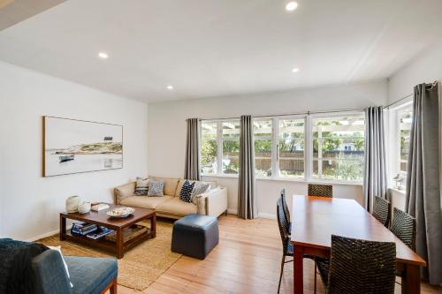 a living room with a table and a couch at Bird and Fish - Napier Holiday Home in Napier