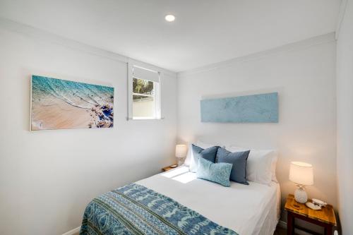 a bedroom with a bed and two pictures on the wall at Bird and Fish - Napier Holiday Home in Napier