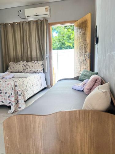 a bedroom with two beds and a window at Fica Aki - Hospedagem Alta Floresta in Alta Floresta