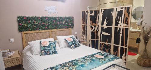 a bedroom with a bed with flowers on it at Le cabanon du plaisir in Montpellier