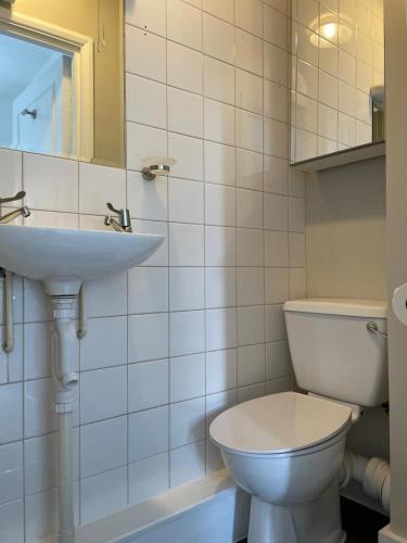 a bathroom with a white toilet and a sink at Self Contained Studio Flat in London