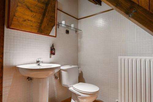 a bathroom with a toilet and a sink at Hotel Nau Iori in Vielha