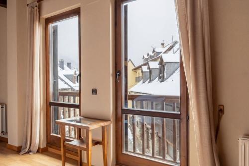 a room with a large window with a view of a building at Hotel Nau Iori in Vielha