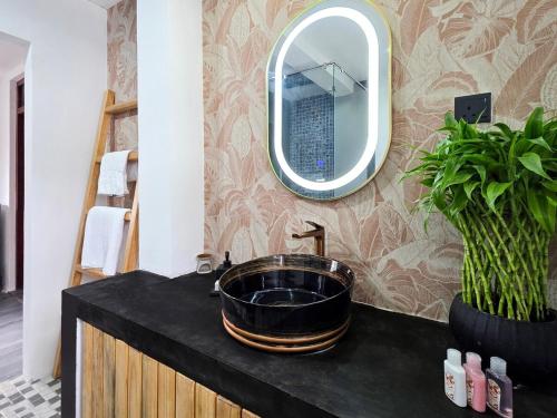 a bathroom with a black sink and a mirror at Evolve SAYA in Talawatugoda