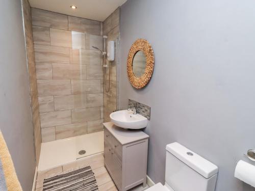 a bathroom with a sink and a toilet and a shower at Corner Cottage in Seahouses
