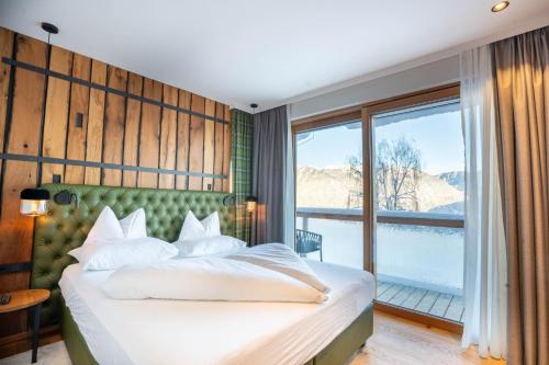 a bedroom with a bed and a large window at Höflehner Premium Eco Lodge in Haus im Ennstal