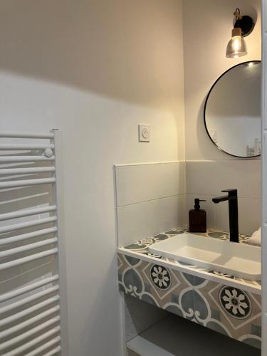 a bathroom with a sink and a mirror at Le Manoir des Sables - Hébergement familial grand confort in Berthegon