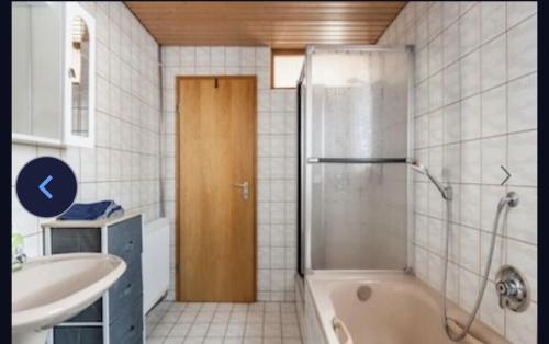 a bathroom with a tub and a shower and a sink at Haus Schwarzwald Marie in Mahlberg