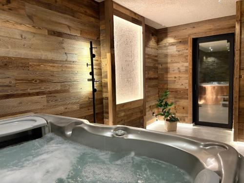 a bath tub in a bathroom with wooden walls at Apartamenty 1006mnpm JACUZZI w cenie in Bustryk
