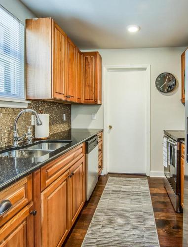 a kitchen with wooden cabinets and a sink at The Southern State of Mind by Stay Local Nashville in Nashville