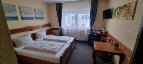 a hotel room with two beds and a desk at 2x Einzelbetten - Gästezimmer - 11min von Gießen Zentrum 8,4km in Fernwald in Steinbach