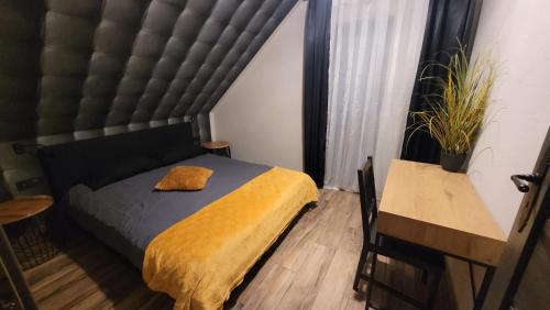 a bedroom with a bed with a yellow blanket at Cudodomek SPA Loft koło Ełku in Ełk